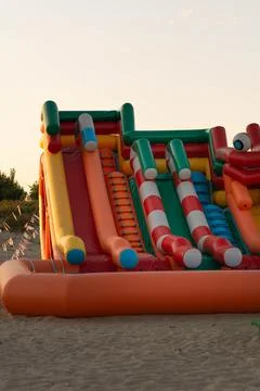 Inflatable rubber slide in the rays of the setting sun on the beach Foto stock