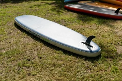 Inflatable stand up paddle board lying on grass in a sunny day 스톡 사진