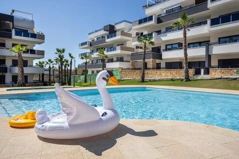 Inflatable swan float by outdoor pool in modern apartment complex Stock Photos