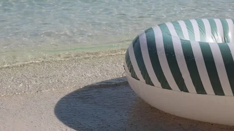 Inflatable swim ring bobbing on sunlit beach waves Stock Footage 318594619
