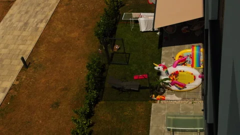 Inflatable Unicorn Pool Toys in Backyard Garden During Hot Summer Stock Footage 341320061