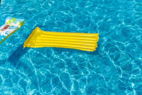 Inflatable water activities mattresses float on the water in the pool. Concep Stock Photos