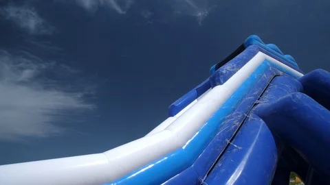 Inflatable Water slide on the Sandy beach. Summer warm day blue Sky. Isolated. Stock-Footage 129379891