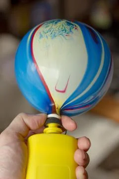 Inflating balloon with the yellow pump. Stock Photos