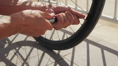 Inflating a Bicycle Tire While Enjoying the Warm Sun Shine at the Beach on a Stock Footage 289669538