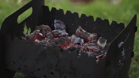Inflating the heat from the coals in the grill Stock Footage 276478271