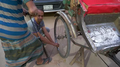 Inflating a punctured rickshaw tyre on the roadside Stock Footage 152977207