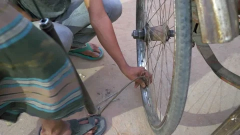 Inflating a repaired cycle Rickshaw tyre on the roadside Video stock 152977304