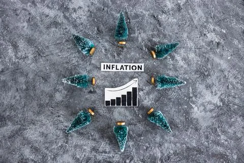 Inflation graph with stats going up surrounded by mini Christmas trees, cos.. Stock Photos