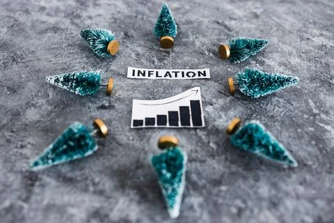 Inflation graph with stats going up surrounded by mini Christmas trees, cos.. Stock Photos