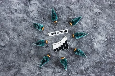 Inflation graph with stats going up surrounded by mini Christmas trees, cos.. Stock Photos