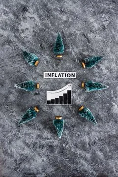 Inflation graph with stats going up surrounded by mini Christmas trees, cos.. Stock Photos