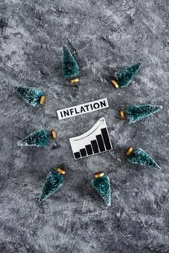 Inflation graph with stats going up surrounded by mini Christmas trees, cos.. Stock Photos
