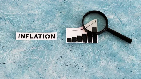 Inflation text and graph showing prices going up with magnifying glass analys Stock Footage 217366711