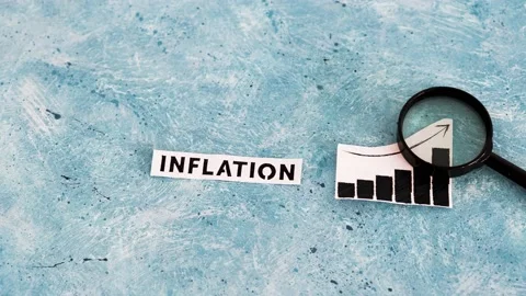 Inflation text and graph showing prices going up with magnifying glass analys Stock Footage 217366753