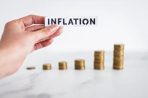 Inflation text in front of growing stacks of coins representing increasingly  Stock Photos