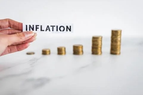 Inflation text in front of growing stacks of coins representing increasingl.. Stock Photos