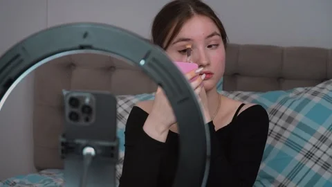 Influencer applying makeup with ring light and mirror Vidéo 311781713