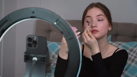 Influencer applying makeup with ring light and mirror 動画素材 311813484