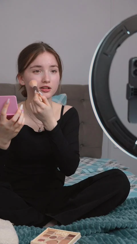 Influencer applying makeup while recording video content Stock Footage 311779812