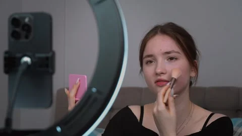 Influencer applying makeup while recording video content Stock Footage 311781283