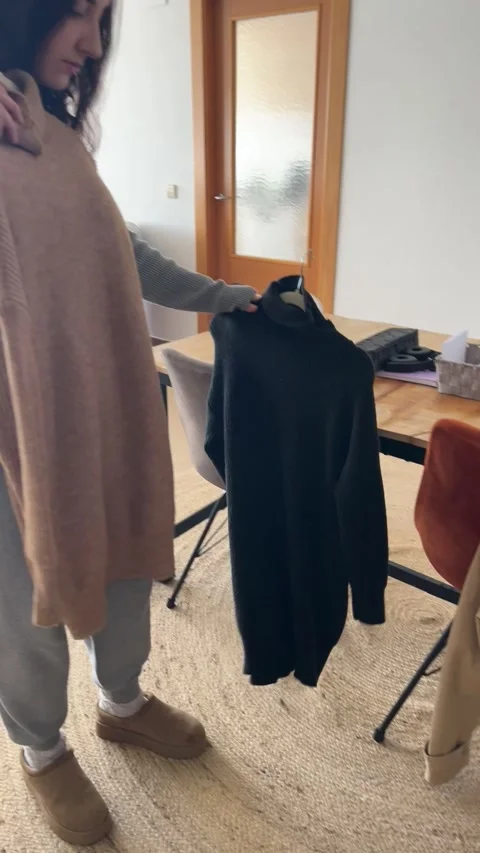 Influencer choosing between two dresses in her recording setup Stock Footage 328102260