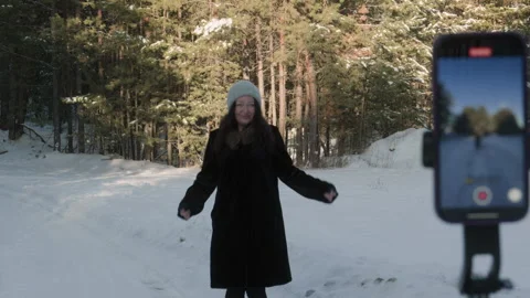 Influencer creating content dancing in snowy forest Stock Footage 302700836