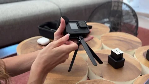 Influencer hands attaching mini tripod to action camera Stock Footage 342498274