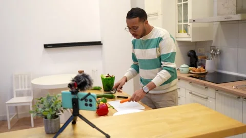 Influencer live streaming a cooking tutorial at home 動画素材 334134136