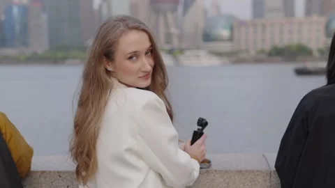 Influencer posing dynamically with gimbal near Shanghai skyline, slow motion Stock Footage 313916748
