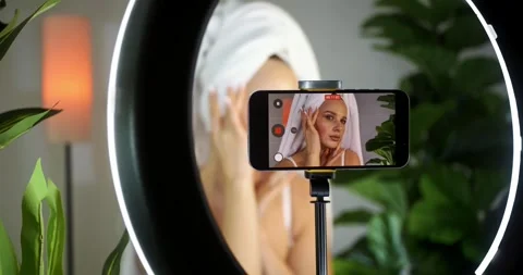 Influencer Recording Makeup Tutorial Indoors with Ring Light 스톡 동영상 323455761