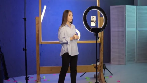 Influencer standing beside ring light in professional studio Video stock 342934513