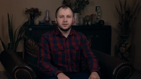 The influential Bearded Young guy, a blogger, of European appearance, sits in a Stock Footage 121206426