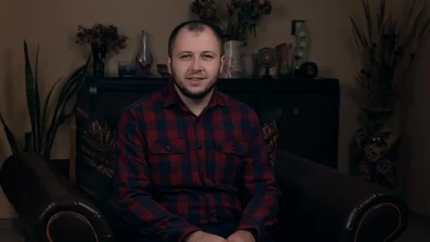 The influential Bearded Young guy, a blogger, of European appearance, sits in a Stock Footage 121206888