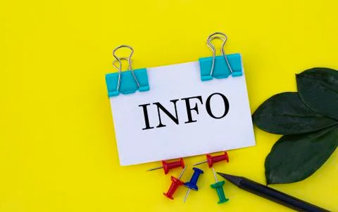 INFO - a word on a white sheet of paper with clips on a yellow background wit Stock Photos