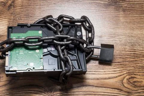 Information security concept, hard disk with chain and padlock. Stock Photos