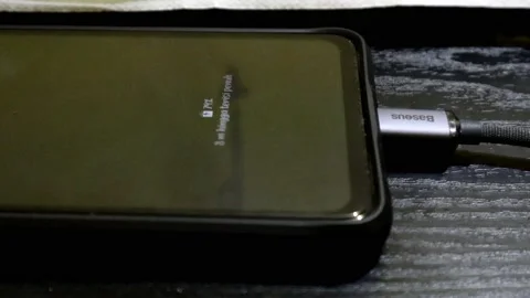 Information on smartphone screen when charging with branded charging cable Stock Footage 237486152