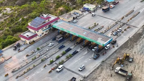 Infrastructure expansion: Heavy machinery working next to a toll plaza. Видео 337761713