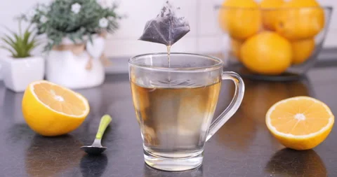 Infusing Tea Bag in Hot Water Mug on Kitchen Counter Stock Footage 327543363