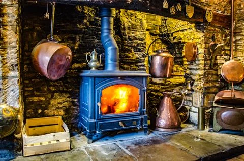 Inglenook fireplace with log burning stove and brass pots Stock Photos