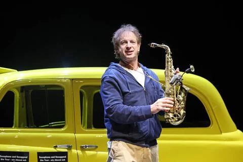 Ingolf Lueck als Sebastian alias Jeremy Cooper mit Saxophon vor gelben Tax... Stock Photos