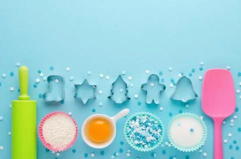 Ingredients for baking and kitchen tools with cookie cutter on blue background Stock Photos