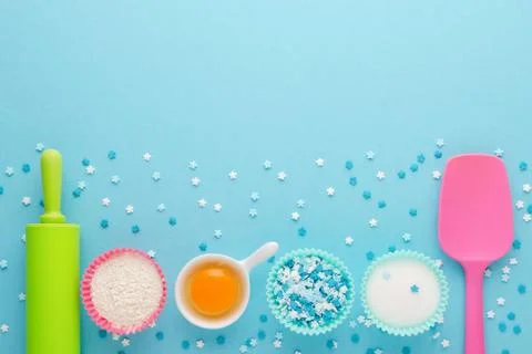 Ingredients for baking and kitchen tools on blue background, flat lay Stock Photos