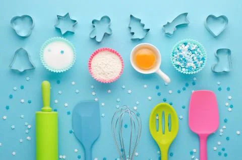 Ingredients for baking and kitchen tools with cookie cutter on blue background Stock Photos
