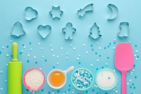 Ingredients for baking and kitchen tools with cookie cutter on blue background Stock Photos