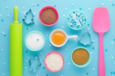 Ingredients for baking and kitchen tools with cookie cutter on blue background Stock Photos