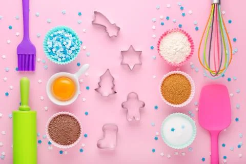 Ingredients for baking and kitchen tools with cookie cutter on pastel pink Stock Photos