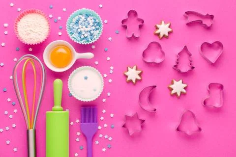 Ingredients for baking and kitchen tools with cookie cutter on pink background Stock Photos