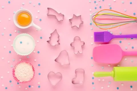 Ingredients for baking and kitchen tools with cookie cutter on pink background Stock Photos