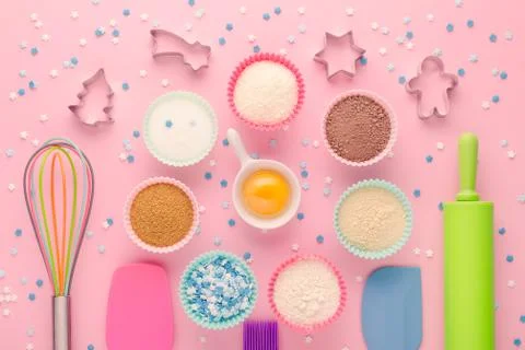 Ingredients for baking and kitchen tools with cookie cutter on pink background Stock Photos